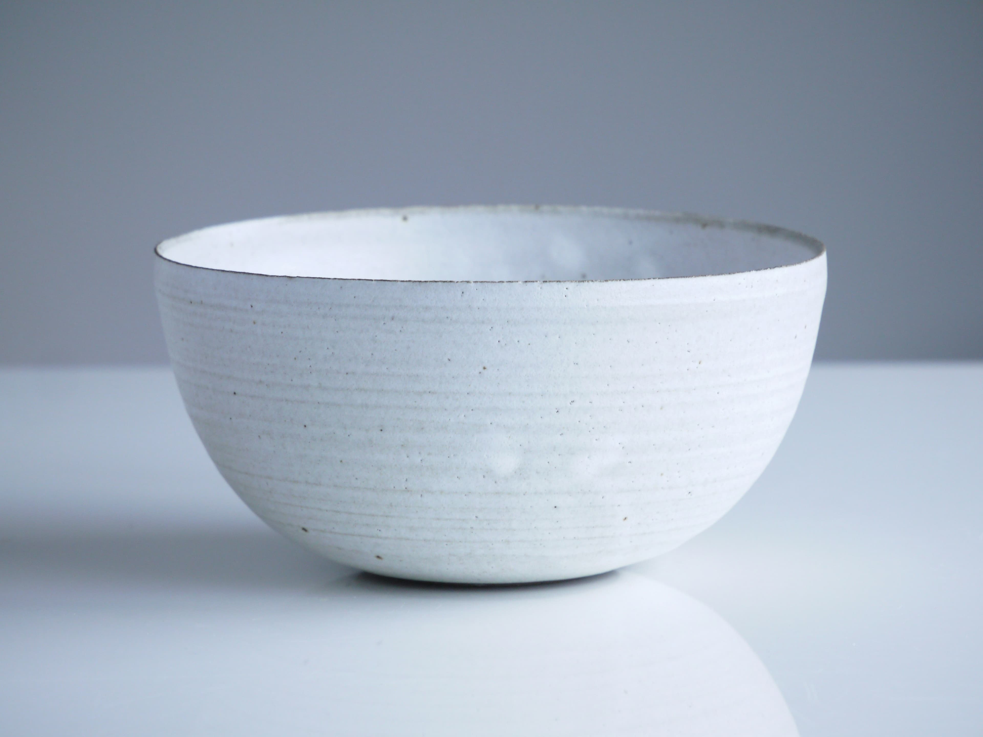 A simple ceramic bowl on a white surface